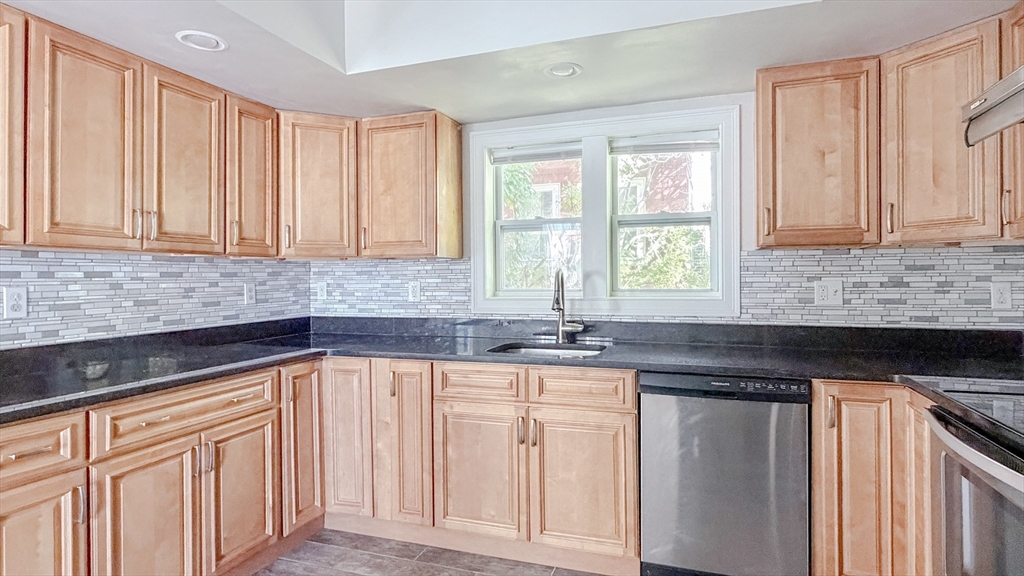 4 Longfellow Road Worcester, MA 01602 - Photo 12 of 36 a kitchen with granite countertop a sink dishwasher stove and cabinets