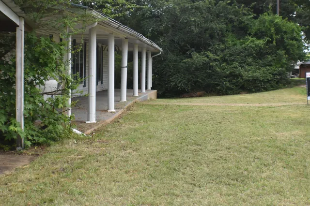 a view of a house with a yard and potted plants