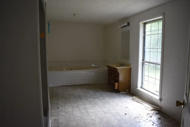 an empty room with windows and closet