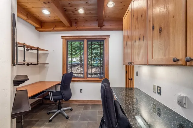 a view of a workspace with furniture and a window