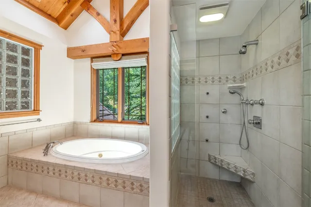 a bathroom with a granite countertop bathtub and shower