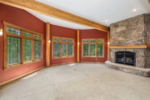 a living room with furniture a large window and a fireplace