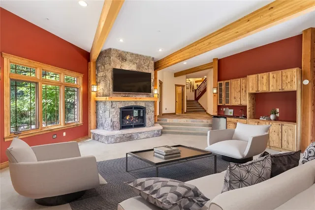 a living room with furniture a large window and a fireplace