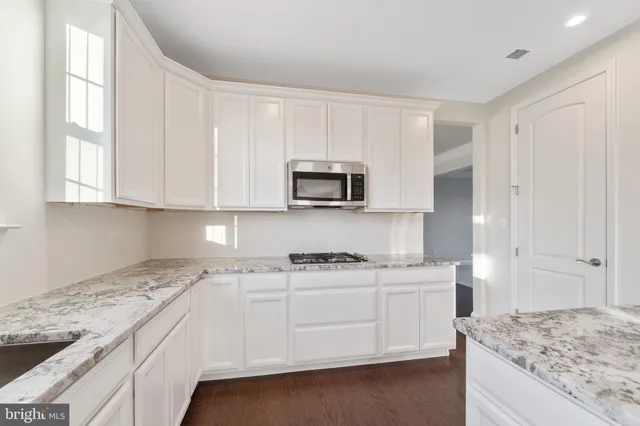 a kitchen with stainless steel appliances and white cabinets