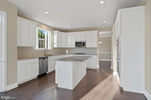 a kitchen with stainless steel appliances granite countertop a refrigerator and a stove top oven