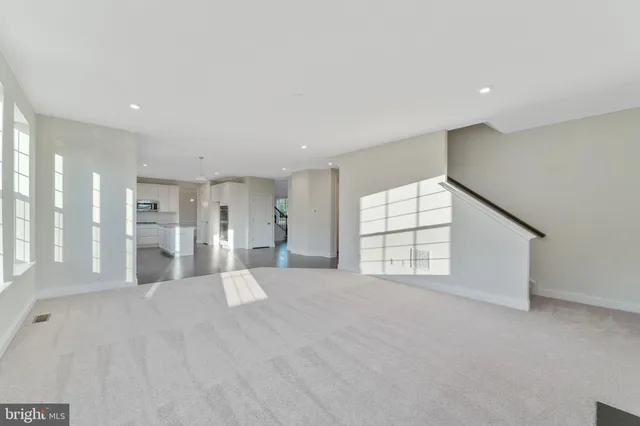 an empty room with windows and fireplace