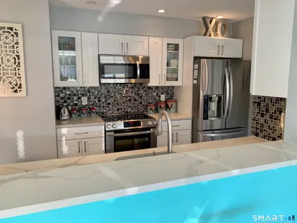 a kitchen with stainless steel appliances a stove microwave and refrigerator