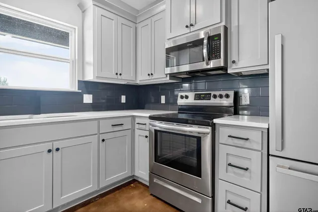 a kitchen with granite countertop white cabinets stainless steel appliances and cabinets