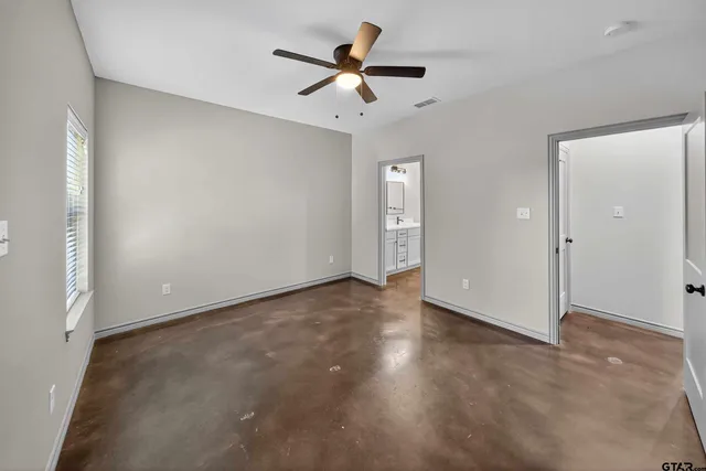 an empty room with closet and a ceiling fan
