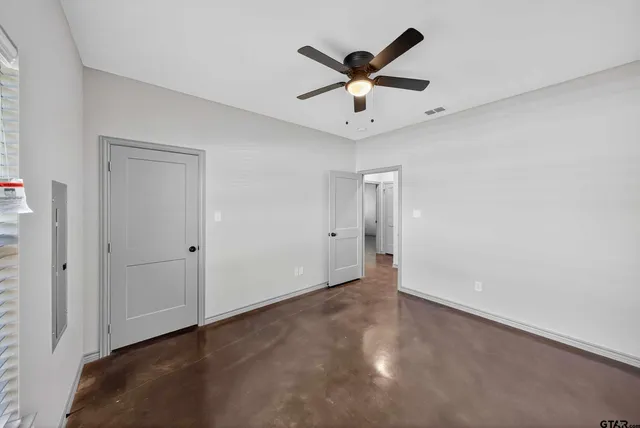 an empty room with a window and a fan
