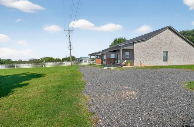 a view of a house with a yard and sitting area