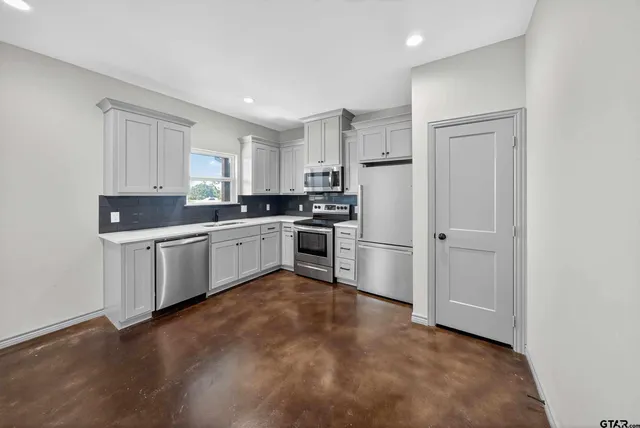 a kitchen with white cabinets and white appliances