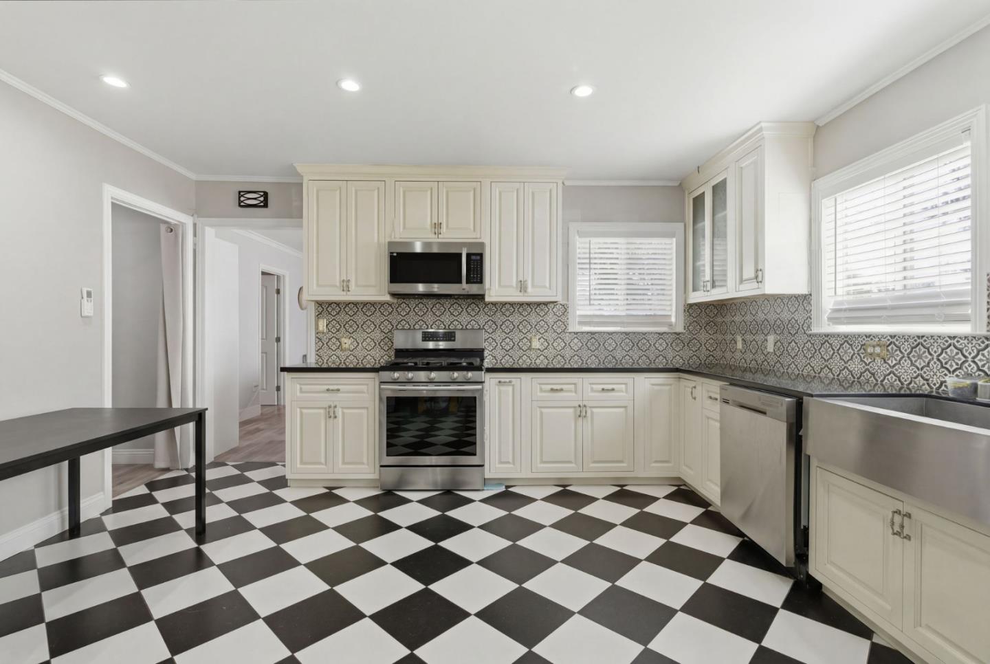 83 North King Road San Jose, CA 95116 - Photo 20 of 51 a kitchen with a checkered floor and white cabinets