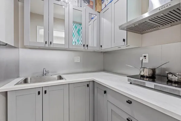 a kitchen with white cabinets and a sink