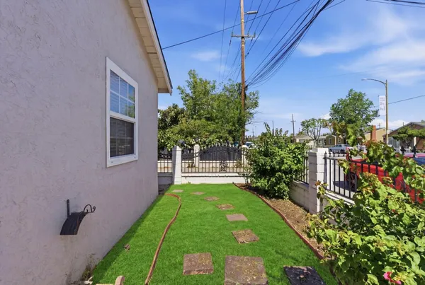 a green field with potted plants in front of door