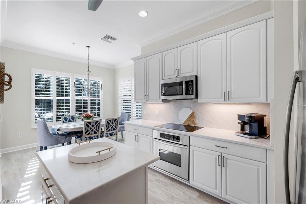 9201 Quartz Lane, Unit 202 Naples, FL 34120 - Photo 13 of 48 a kitchen with stainless steel appliances a white stove top oven and white cabinets
