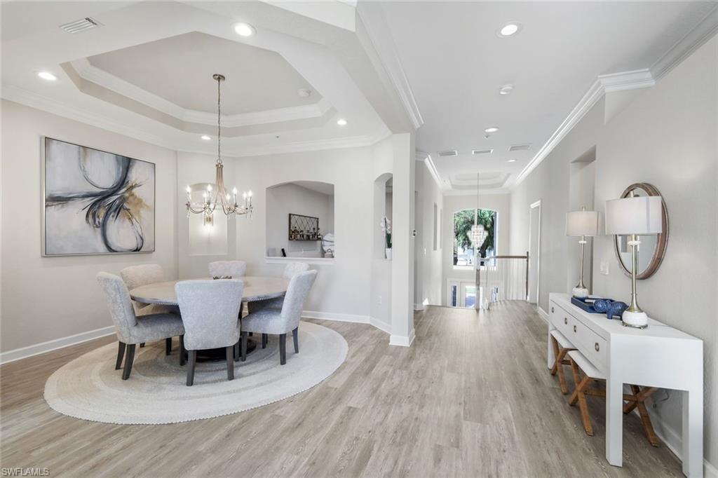 9201 Quartz Lane, Unit 202 Naples, FL 34120 - Photo 17 of 48 a view of a dining room with furniture a chandelier and wooden floor