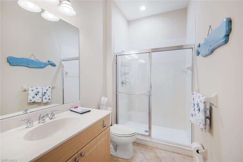 9201 Quartz Lane, Unit 202 Naples, FL 34120 - Photo 26 of 48 a bathroom with a sink vanity mirror and toilet