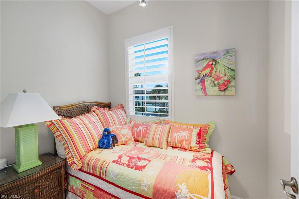 9201 Quartz Lane, Unit 202 Naples, FL 34120 - Photo 27 of 48 a bedroom with a bed and a painting on the wall