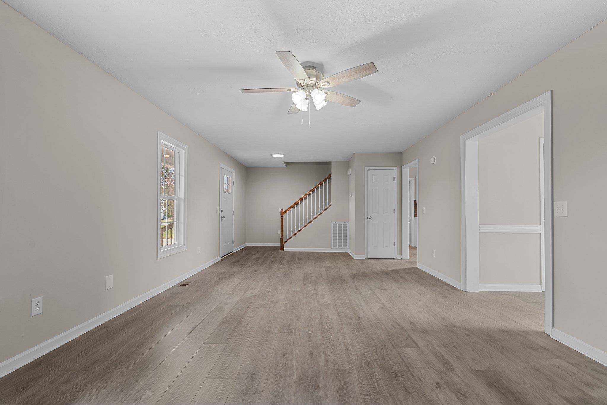 71 Preston Way Lillington, NC 27546 - Photo 4 of 19 a view of an empty room with wooden floor and a ceiling fan