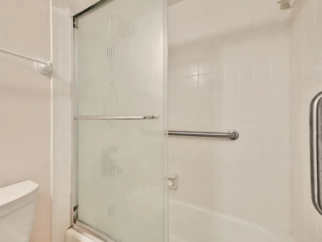 a bathroom with a granite countertop toilet sink and mirror