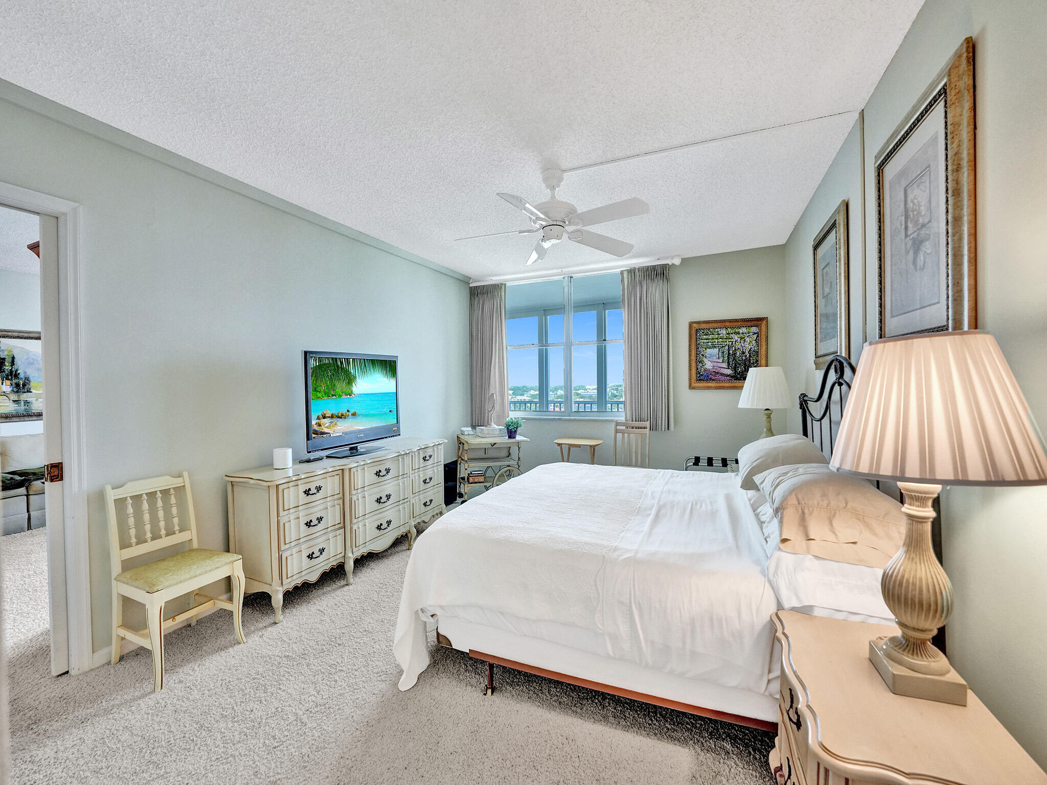 3300 South Ocean Boulevard, Unit 1021C Highland Beach, FL 33487 - Photo 26 of 45 a spacious bedroom with a bed and a chandelier