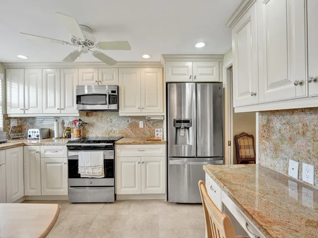a kitchen with kitchen island granite countertop a stove a sink and a refrigerator