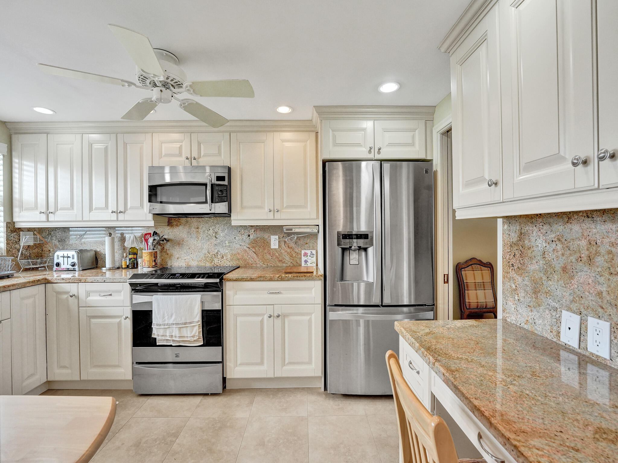 3300 South Ocean Boulevard, Unit 1021C Highland Beach, FL 33487 - Photo 3 of 45 a kitchen with kitchen island granite countertop a stove a sink and a refrigerator