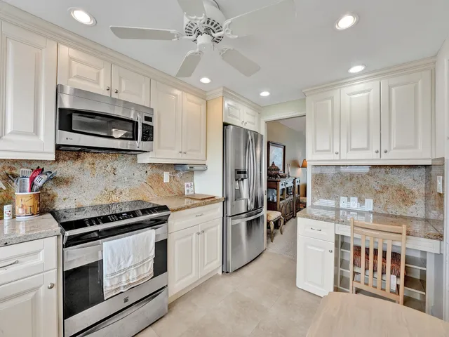 a kitchen with stainless steel appliances kitchen island granite countertop a stove sink microwave and cabinets