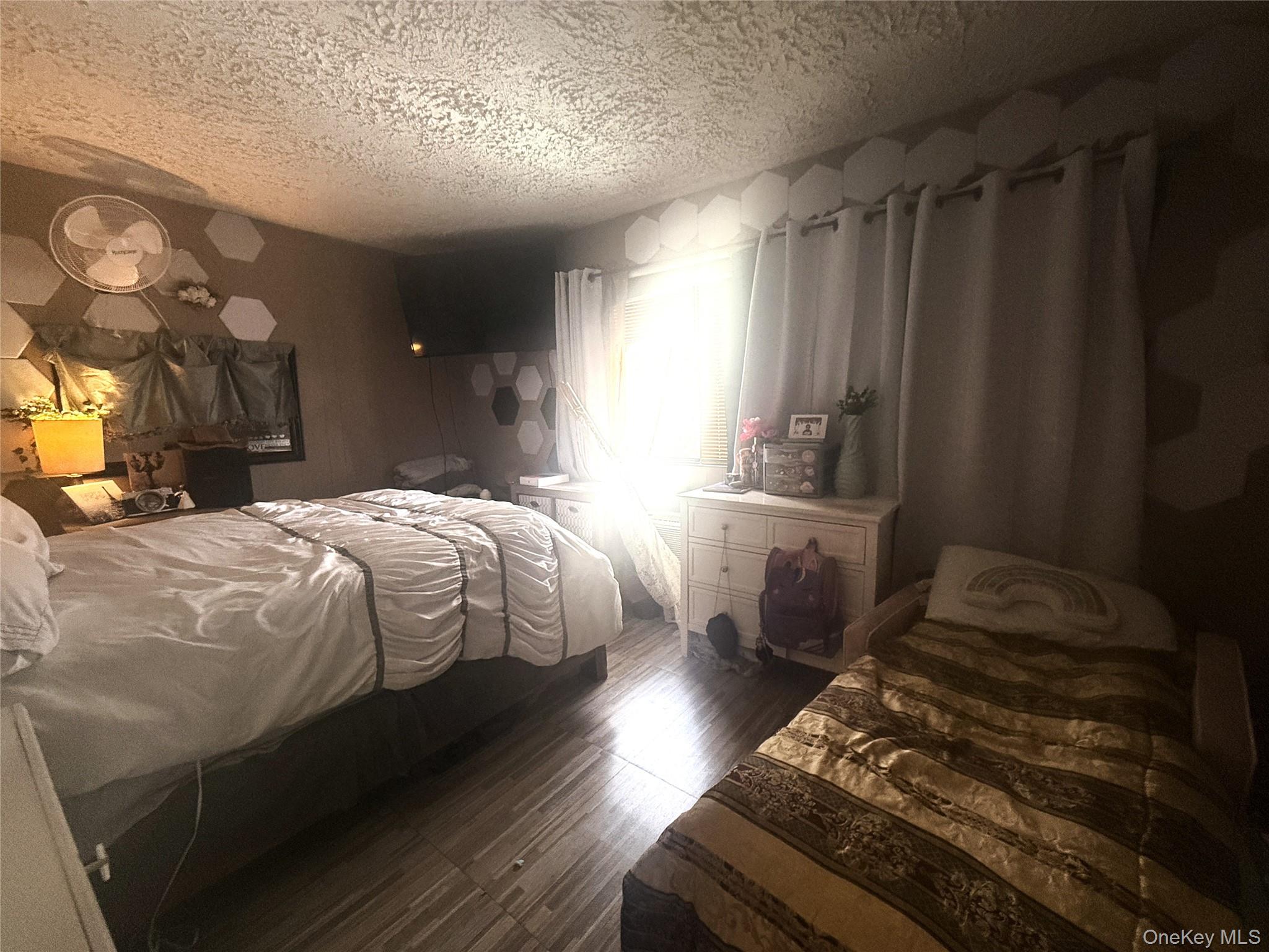 37 Robert Road Kiamesha Lake, NY 12751 - Photo 7 of 25 a bed sitting in a bedroom next to a window and a chandelier