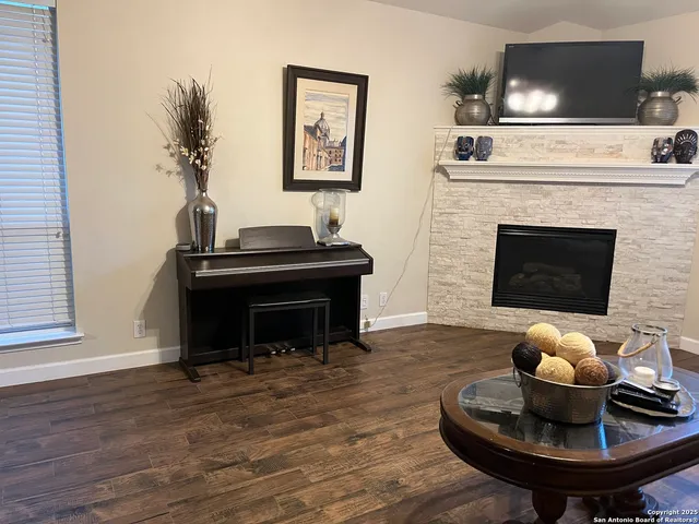 a living room with furniture a fireplace and a flat screen tv