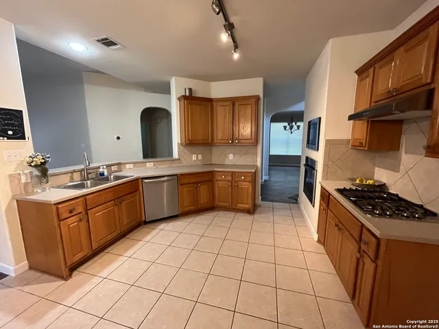 a kitchen with stainless steel appliances granite countertop a sink and cabinets