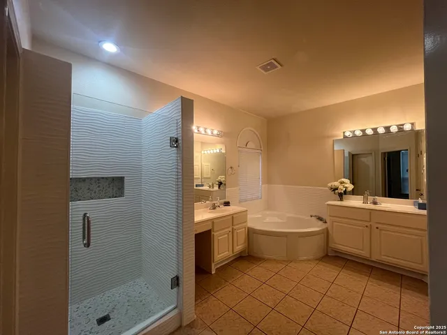 a bathroom with a double vanity sink a toilet a shower and a mirror