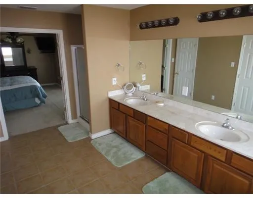 a spacious bathroom with a granite countertop sink and a mirror