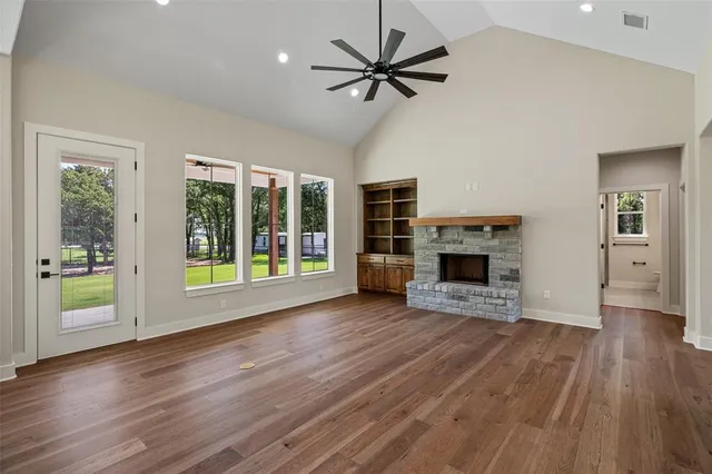 a view of a livingroom with wooden floor a fireplace and window