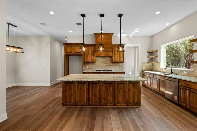a large kitchen with a lot of counter space and a wooden floor