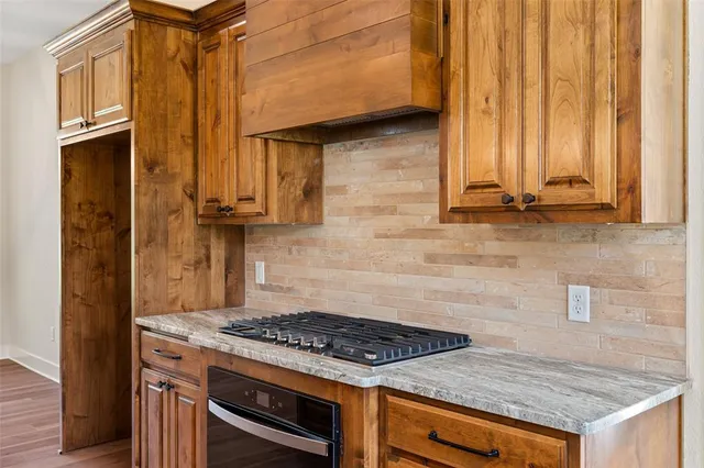a kitchen with granite countertop a stove and a refrigerator