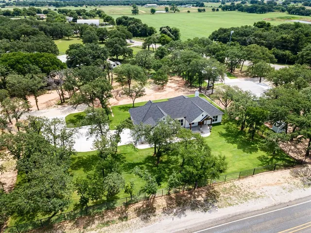 an aerial view of a house with yard and green space