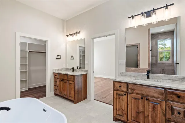a spacious bathroom with a granite countertop double vanity sink and a mirror