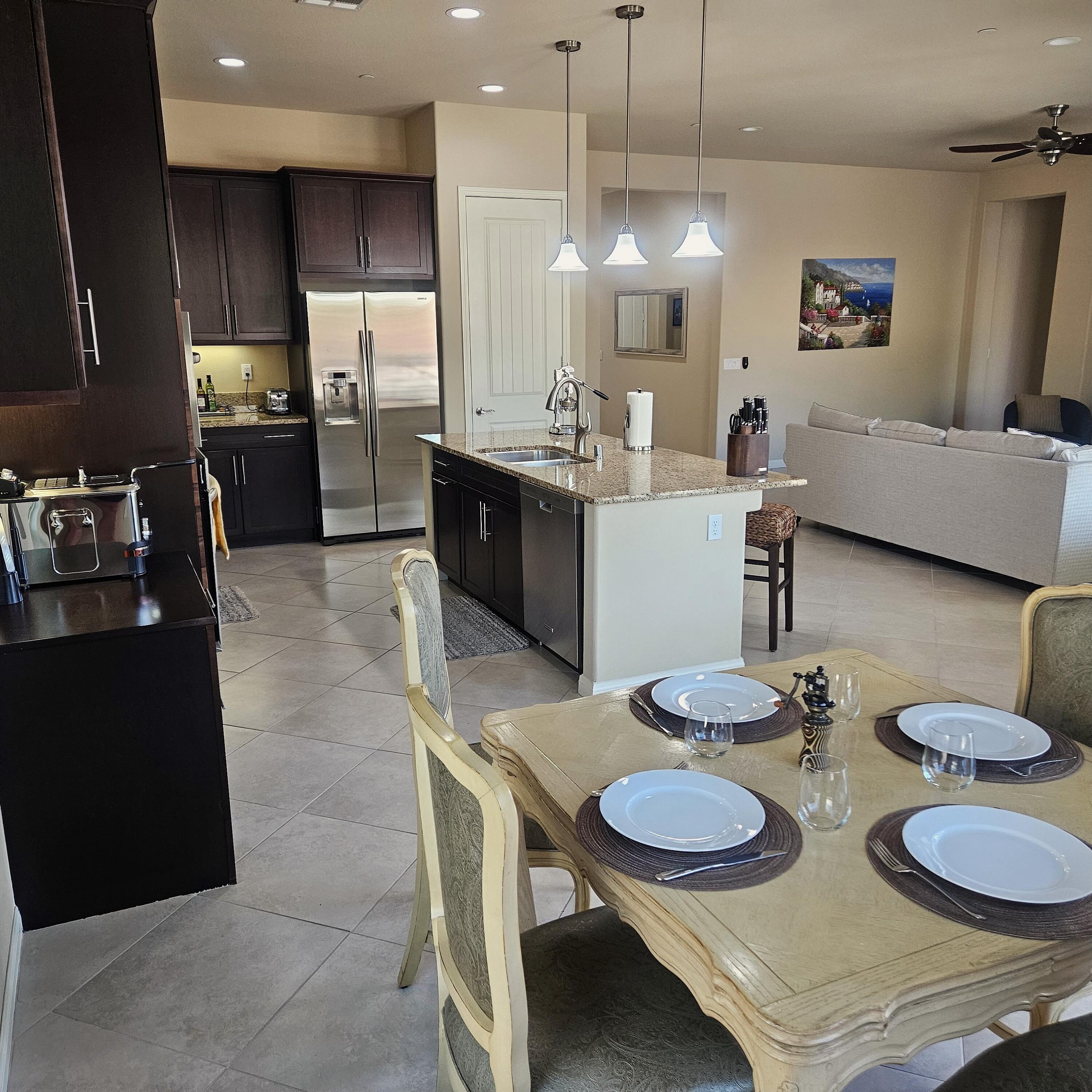 81672 Avenida Viesca Indio, CA 92203 - Photo 5 of 56 a kitchen with stainless steel appliances granite countertop a sink a stove a dining table and chairs