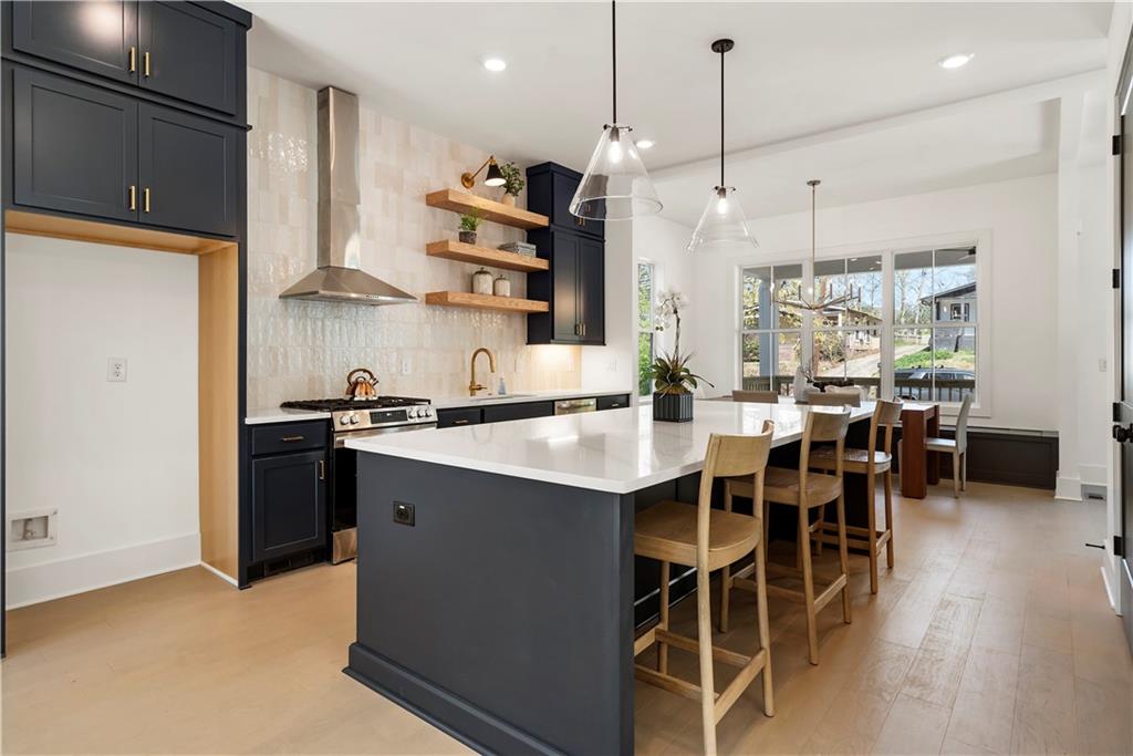 1901 Browns Mill Road Southeast Atlanta, GA 30315 - Photo 13 of 42 a kitchen with stainless steel appliances granite countertop a sink a stove a refrigerator and island with wooden floor