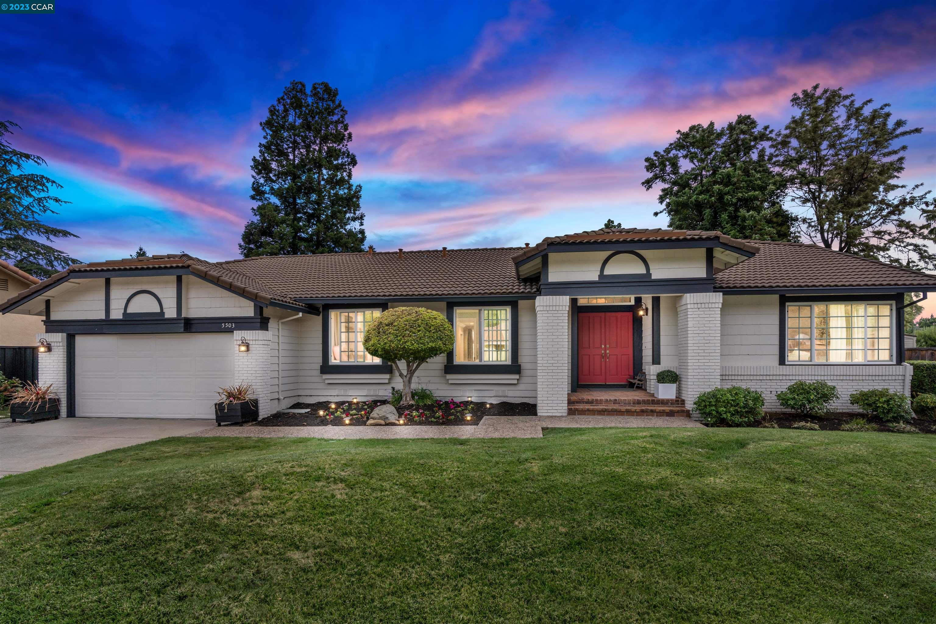 a front view of a house with a yard and garage