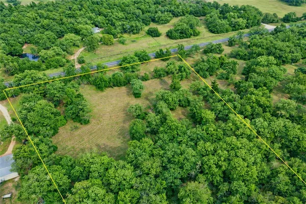 an aerial view of residential house with outdoor space and trees all around