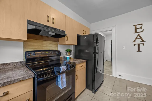 a kitchen with a refrigerator and a stove