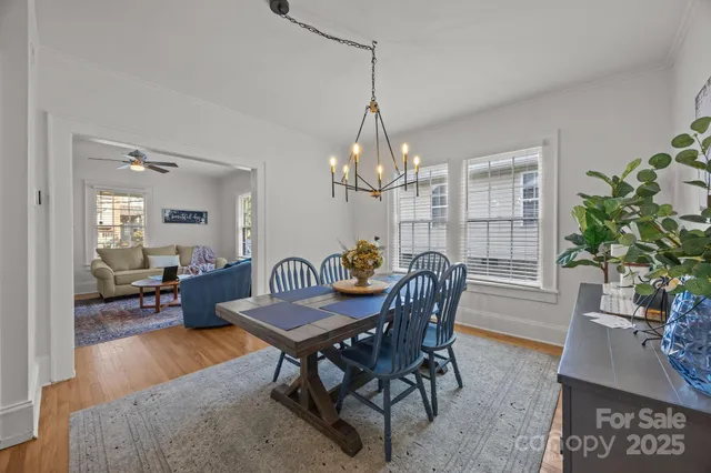 a dining room with furniture a chandelier and wooden floor
