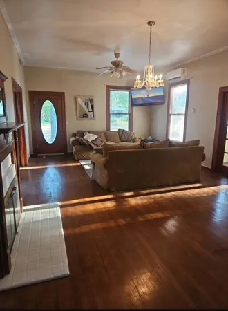 a living room with table chairs and a wooden floor