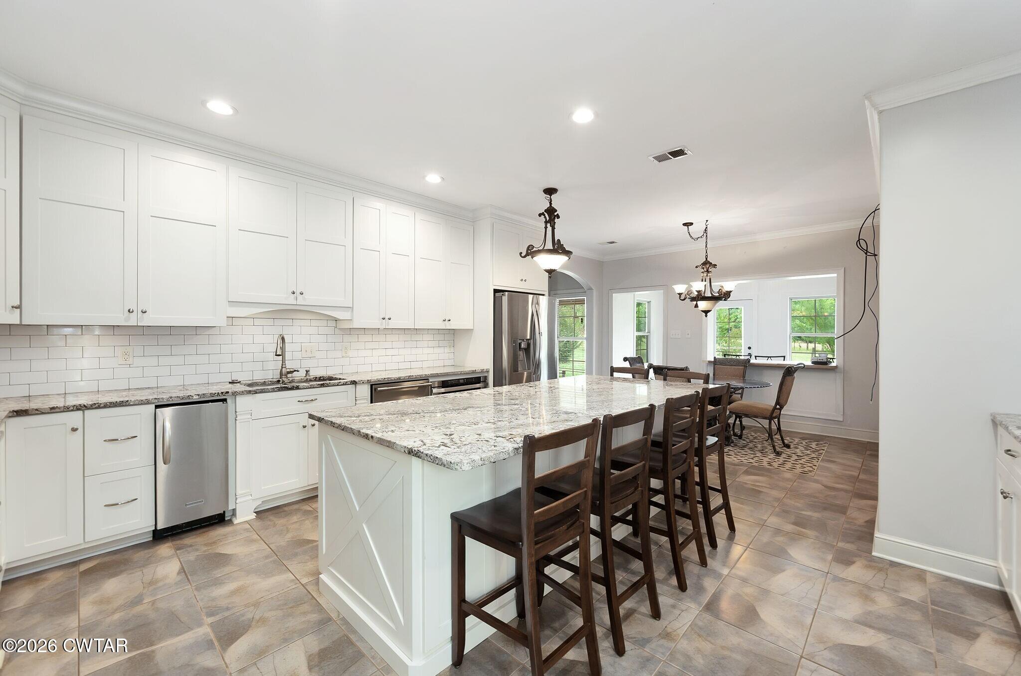 4080 Beech Bluff Road Beech Bluff, TN 38313 - Photo 14 of 41 a kitchen with kitchen island granite countertop wooden cabinets and white stainless steel appliances