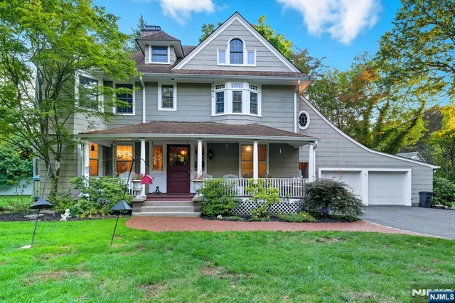 a front view of a house with a yard and trees