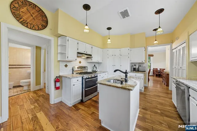 a kitchen with stainless steel appliances granite countertop a sink a stove and a refrigerator