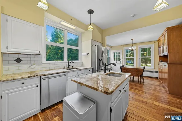 a open kitchen with stainless steel appliances granite countertop a sink stove and wooden cabinets